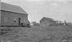 Two [indigenous] men in front of buildings, Lampson - Hubbard Co., Lot 13 24 June 1921.