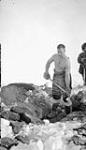 [Richard Finnie digging a grave for the burial of an Inuk woman] Original title: Richard Finnie digging grave for burial of native woman 1931