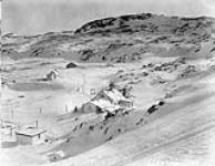 Résidence de la Compagnie de la Baie d'Hudson au premier plan, église anglicane à mi-chemin et station du ministère de l'Intérieur plus loin. Lake Harbour, île de Baffin, Territoires du Nord-Ouest Early March 1931.