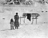 [Inuuk woman and child, winter scene at Kimmirut] Original title: Native winter scene at Lake Harbour March 1931.