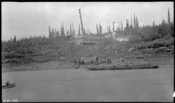 [Barge near shore, tent and building on shore] 1920
