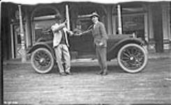 [Three men with a car in front of the Royal Alexandra Hotel] 1920