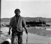 [New-king-yah, an Inuk man, skinning whale hides] Original title: Native New-king-yah skinning whale hides 1936