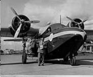 [Russ Baker (standing) and Jack Crosby with a Grumman 'Mallard' aircraft of Pacific Western Airlines at Vancouver, Airport, 1952.] 1952