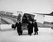 Friends and colleagues of Russ Baker with his coffin at the time of his last flight in a Douglas DC-3 aircraft of Pacific Western Airways Nov. 21, 1958