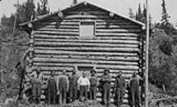 First cabin at La Bine Point.Gilbert Labine at left, Charles and Jack Labine 3rd & 4th from left n.d.