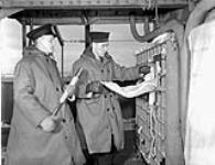 Unidentified signals personnel at the flag locker of the armed merchant cruiser H.M.C.S. PRINCE DAVID, Halifax, Nova Scotia, Canada, January 1941 January, 1941.