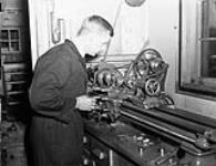An Electrical Artificer operating a lathe in the Electrical Artificers' Workshop, H.M.C. Dockyard, Halifax, Nova Scotia, Canada, 18 November 1942 November 18, 1942.
