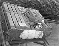Seaman checking a life raft aboard an unidentified merchant ship, Halifax, Nova Scotia, Canada, 29 November 1942 November 29, 1942.