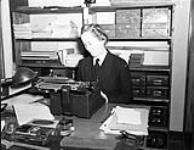 Wren Writer M. McDonald of the Women's Royal Canadian Naval Service (W.R.C.N.S.) working in the navigation library at H.M.C.S. KINGS, Halifax, Nova Scotia, Canada, 3 March 1943 March 3, 1943.