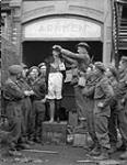 Lance-Corporal E.C. Crook of The Perth Regiment adjusting the hat of a mannequin, Arnhem, Netherlands, 15 April 1945 April 15, 1945.