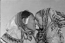 A woman [Iggi (Kigutaitu)] and unidentified girl giving each other a kunik ca. 1949-1950.