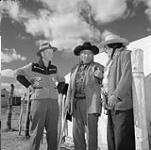 Senator James Gladstone, first Indian Senator, left; George Callinglast, centre; Howard Hindman, right, on the Blood Indian Reserve, north of Cardston Septembre 1958