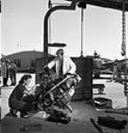 Aircraft inspector with C.P.A. checks motor, Edmonton airport, Alta., September 1943 Sept. 1943