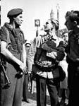 Pte. W.J. Forrester, Royal Canadian Army Service Corps (R.C.A.S.C.), attached to the Algonquin Regiment, talking to Josef Sayes, member of the Belgian White Army, Bruges, Belgium, 13 September 1944 September 13, 1944.
