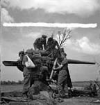 Canadian Film and Photo Unit personnel with a captured German 88mm anti-aircraft gun near Bayeux, France, 26 August 1944 August 26, 1944.
