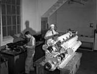 Workers tuning up a Packard motor to be installed in a motor torpedo boat under construction at Canadian Power Boat Company, Montreal, Québec, Canada, 24 April 1941 Apri1 24, 1941.