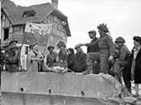 Infantrymen of Le Régiment de la Chaudière talking with French civilians, Bernières-sur-Mer, France, 6 June 1944 June 6, 1944.