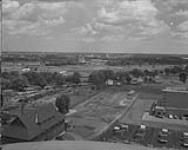 [Central Experimental Farm, Ottawa Ontario. Cereal Division Plots, part south east from water tower of Macoun gardens showing Piggeries and Heating Plant.] [28 June 1961]