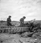 Privates H.H. de Vries and M.A. Sallows of the 9th Canadian Infantry Brigade examining a destroyed German 122mm. gun, Fontaine-Henry, France, 2 July 1944 July 2, 1944.