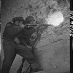 Two riflemen at loopholes in fort at southern edge of town 23-Jul-44
