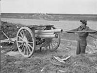Private N. Sammenko of the Highland Light Infantry of Canada cleaning 7. 62cm. gun abandoned by German forces near the Afsluitdijk across the Zuiderzee 19 Apr. 1945