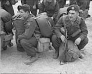 Brigade changeover in Korea. Ptes. W.A. Grieves and J.C. Godin, medic and ambulance driver, waiting for their names to be called 10 Apr. 1952