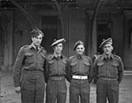 Private Stanley Dudka, Corporal John Leslie Kelly, L/Corporal Ernest Alexander Mabee and Corporal Angus Donald MacLeod (left to right) receiving Military Medal at Buckingham Palace 20 Mar. 1945