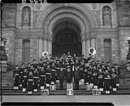Royal Canadian Navy Band on steps of Legislative Building, Victoria, B.C. Centre front, from left to right: Lt. F. Hardwick, Lt. H. Cuthbert, Acting Gunner Wm. Green 1 Dec. 1943
