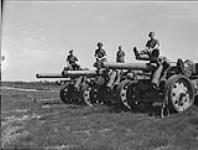 Captured German heavy artillery, with members of the Gloucester Regiment standing on top of the gun barrels 10 May 1945.