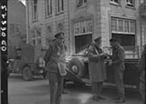 Prince Bernhardt of the Netherlands and two Canadian officers outside building of peace surrender conference 5 May 1945