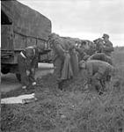 Lance-Corporal J.G. Kallenberger searching a group of German prisoners en route back to Germany, Den Helder, Netherlands, 27 May 1945 May 27, 1945.