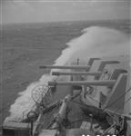 Waves break over bow of H.M.C.S. UGANDA of British Pacific Fleet Aug. 1945