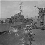 H.M.C.S. UGANDA of British Pacific Fleet gives fuel to fleet tanker 7 Aug. 1945