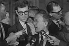 Le leader néo-démocrate, l'hon. T.C. (Tommy) Douglas est interrogé par des journalistes à la sortie de la Chambre des Communes après la clôture du débat et le vote sur le nouveau drapeau canadien décembre 1965