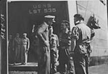 British and Canadian Troops landing in Koje-do Island. Col. P.R. Henderson, C.O. of the Commonwealth Forward Maintenance Area, Korea (wearing cap) confers with Major Dawnay Bancroft of the King's Shropshire Light Infantry (KSLI) before troops disembark c.a. 1952