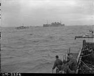 View from LCI(L) 306 of the 2nd Canadian (262nd RN) Flotilla, showing HMS LLANGIBBY CASTLE and other landing craft of Force 'J' off the coast of France on D-Day 6 June 1944
