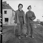 Essex Scottish Pte. J.A. Napier sporting a top hat and a cane, and Queen's Own Camerons of Winnipeg Pte. A.V. Turner carrying a stray chicken. Marienboum, Germany, 7 Mar. 1945 7 MAR. 1945