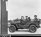 Hon. Clement Atlee (second from left) and Lieutenant-General A.G.L. McNaughton (extreme right) in jeep inspectging airfield being built by personnel of the Royal Canadian Engineers. Dunsfold, England, 2 July 1942 2 JULY 1942