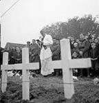 H/Captain Father B.W. Kenny officiating at the burial of 55 infantrymen of "A" Company, The Black Watch (Royal Highland Regiment) of Canada, Ossendrecht, Netherlands, 26 October 1944 October 26, 1944.