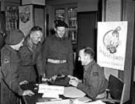 Craftsman T.A. Lyman (right) of the Royal Canadian Electrical and Mechanical Engineers (R.C.E.M.E.) operating the Beaver Club flower service, which accepts orders for telegraphing flowers home, Groningen, Netherlands, 2 June 1945 June 2, 1945.