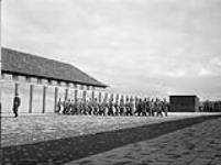 Prisoners drilling on the parade square at No.1 Canadian Field Punishment Camp (Canadian Army Miscellaneous Units), Vught, Netherlands, ca. 21-23 April 1945 [ca. April 21-23, 1945].