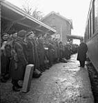 Personnel of The Cameron Highlanders of Ottawa (M.G.) and unidentified British soldiers preparing to board the first leave train en route to England, Oisterwijk, Netherlands, 31 December 1944 Deember 31, 1944.