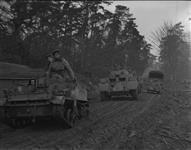 Canadian Army vehicles moving forward through a small forest 6 Mar. 1945