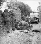 Members of the Regimental Aid Party of the Cameron Highlanders of Ottawa treating a wounded soldier near Caen, France, 15 July 1944 July 15, 1944.