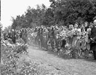Personnel of 1st Canadian A.G.R.A. and Dutch civilians singing the Dutch national anthem at a memorial service for Allied military personnel 6 June 1945