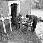 Corporal W.F. Blackwood and Private R.J. Barnes, both of the Pioneer Platoon, The Seaforth Highlanders of Canada, preparing grave crosses for casualties, Baranello, Italy, 19 October 1943 October 19, 1943.