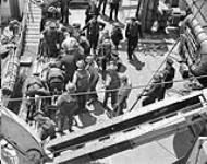 A wounded Royal Navy Beach Commando being taken aboard H.M.C.S. PRINCE DAVID off the Normandy beachhead, France, 6 June 1944 June 6, 1944.