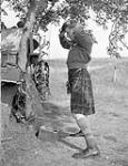 Captain Peter K. Kennedy, a company commander of The Highland Light Infantry of Canada, dressing for Sunday dinner, Thaon, France, 6 August 1944 August 6, 1944.