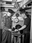 Leading Seaman J.B. Cloke (left) of the Royal Canadian Navy Beach Commandos talking with Leading Seaman J. Forsyth aboard a Landing Craft Infantry (Large) en route to France, 20 July 1944 July 20, 1944.